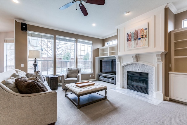 living room featuring light carpet, ceiling fan, crown molding, and a tiled fireplace