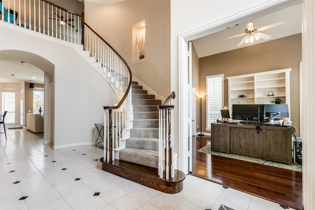 stairway featuring ceiling fan and tile patterned flooring