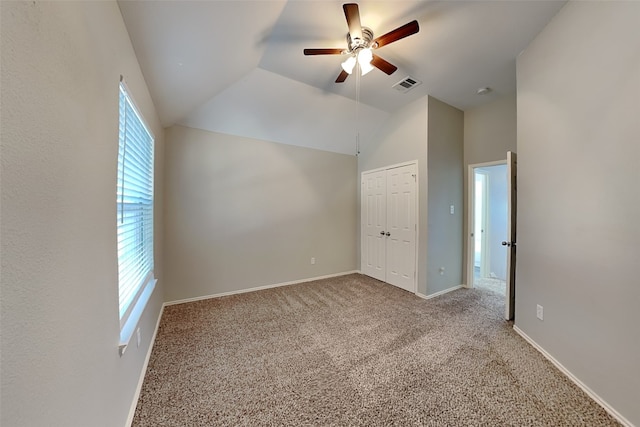 spare room featuring vaulted ceiling, ceiling fan, light carpet, and plenty of natural light