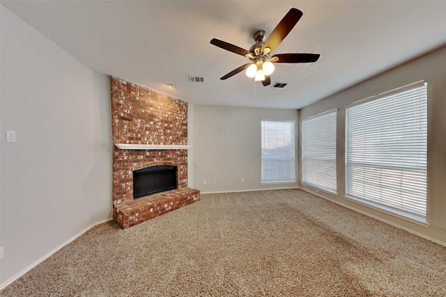 unfurnished living room featuring carpet floors, ceiling fan, and a brick fireplace