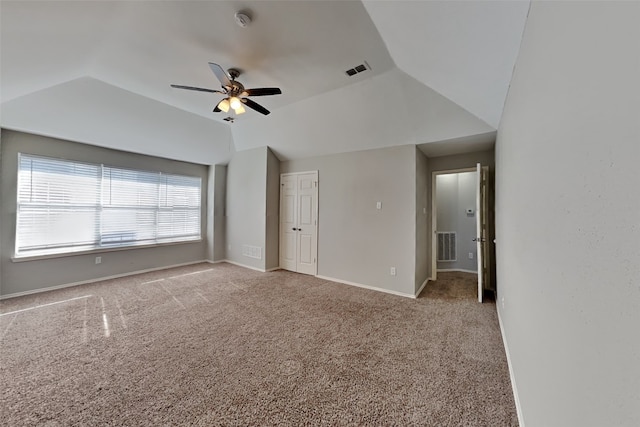 interior space with ceiling fan, light colored carpet, and vaulted ceiling