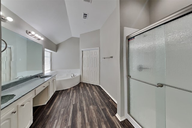 bathroom featuring hardwood / wood-style flooring, vanity, lofted ceiling, and plus walk in shower