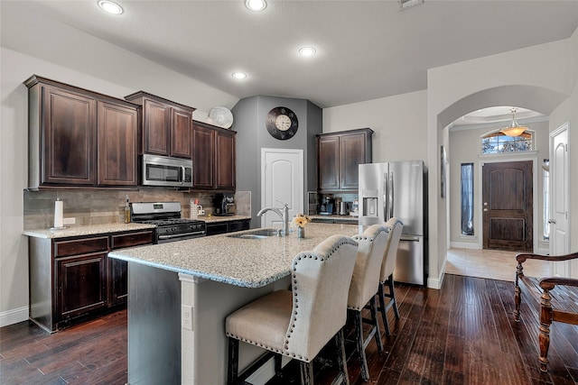 kitchen featuring sink, tasteful backsplash, dark hardwood / wood-style floors, a center island with sink, and stainless steel appliances