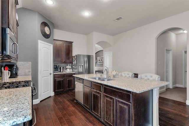 kitchen featuring sink, a kitchen island with sink, a breakfast bar area, and appliances with stainless steel finishes