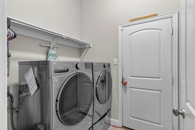 laundry room featuring washing machine and dryer and tile patterned floors