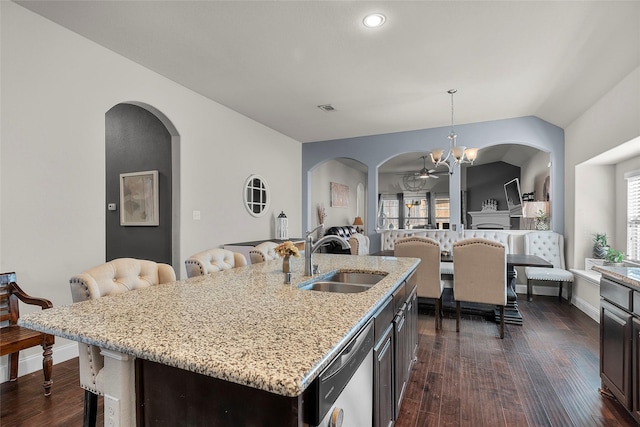 kitchen featuring sink, dishwasher, dark brown cabinetry, and a center island with sink