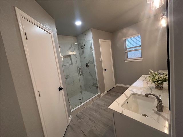 bathroom with a shower with door, wood-type flooring, and vanity