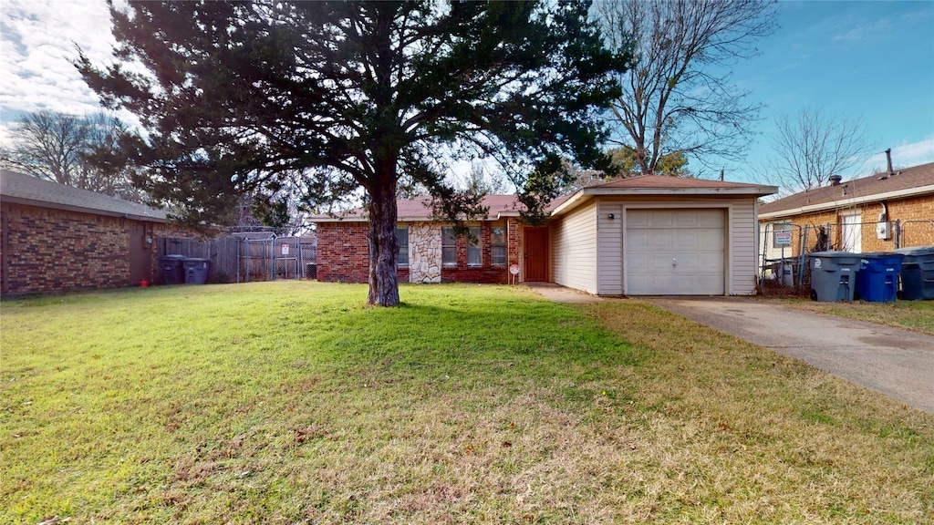 ranch-style home with a front yard, an outdoor structure, and a garage