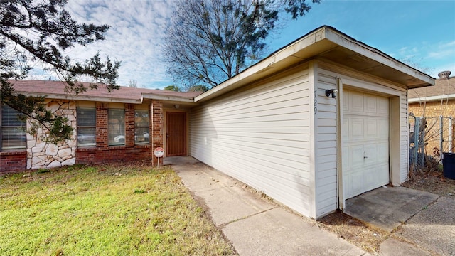 view of exterior entry with a garage and a lawn