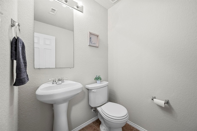 bathroom with toilet, baseboards, visible vents, and tile patterned flooring