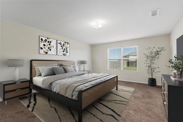 bedroom with visible vents, dark carpet, a textured ceiling, and baseboards