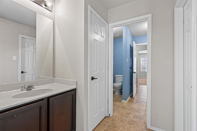 bathroom featuring tile patterned floors, vanity, and toilet