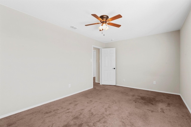 spare room featuring carpet floors, baseboards, visible vents, and ceiling fan