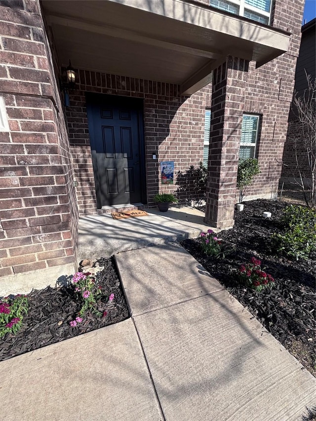 view of exterior entry with brick siding