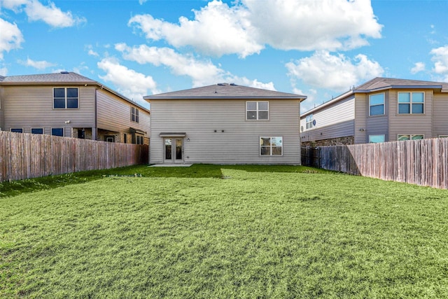 back of property with a lawn and french doors