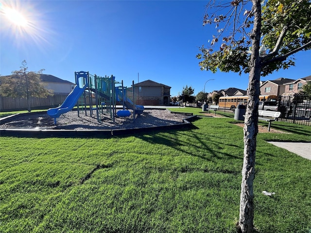 community jungle gym with a yard and fence