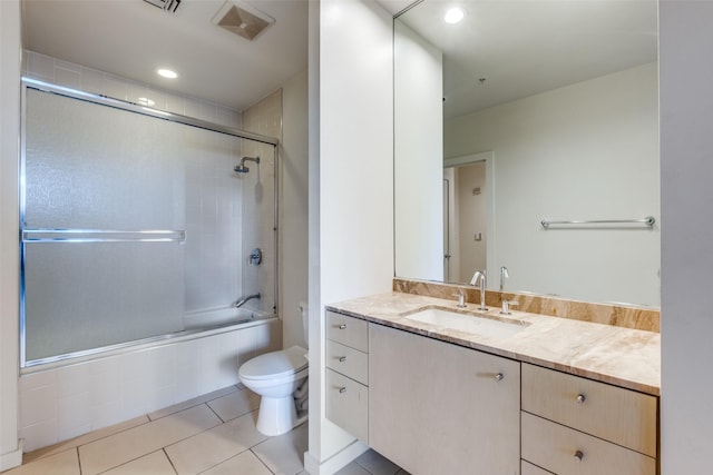 full bathroom with toilet, vanity, tile patterned floors, and shower / bath combination with glass door