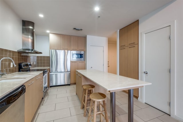 kitchen featuring ventilation hood, appliances with stainless steel finishes, backsplash, a kitchen island, and sink