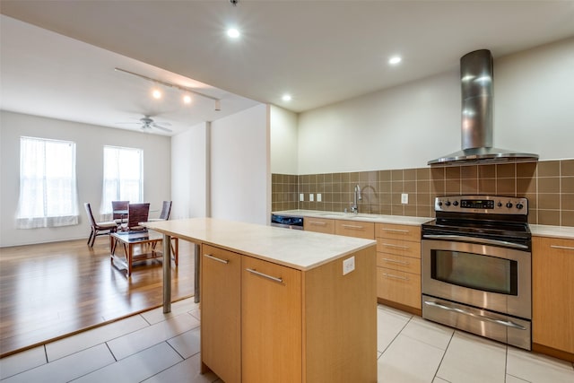 kitchen with exhaust hood, a kitchen island, stainless steel electric stove, track lighting, and light tile patterned floors