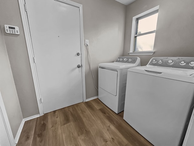 laundry area with wood-type flooring and washing machine and clothes dryer