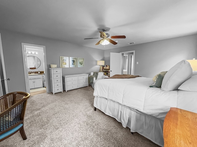 bedroom featuring ceiling fan, ensuite bathroom, and carpet flooring