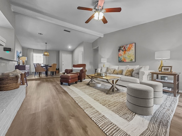 living room with light hardwood / wood-style floors, vaulted ceiling with beams, and ceiling fan