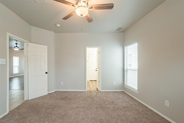 unfurnished bedroom featuring ceiling fan and light colored carpet