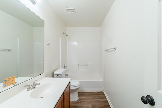 full bathroom with hardwood / wood-style floors, toilet, vanity, and shower / washtub combination