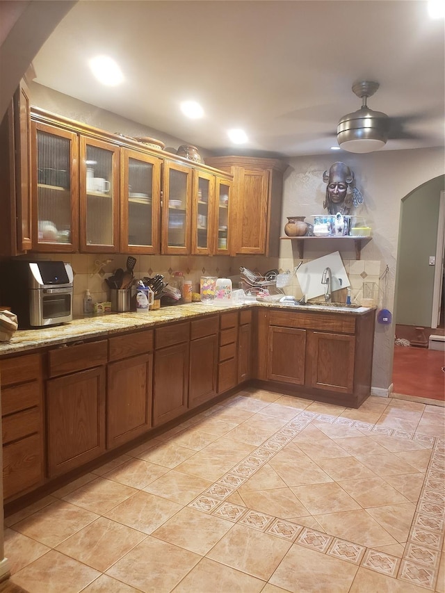 kitchen with light stone countertops, light tile patterned floors, and sink