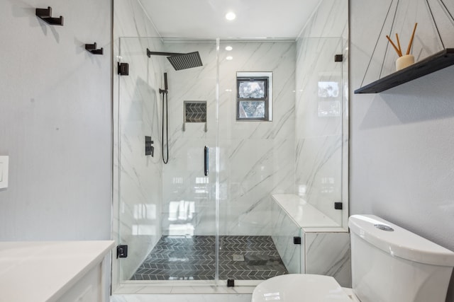 bathroom featuring a shower with shower door, toilet, and vanity