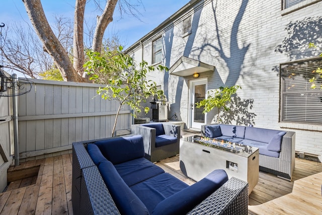 wooden deck featuring an outdoor living space with a fire pit