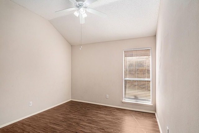 empty room with dark hardwood / wood-style flooring, a textured ceiling, lofted ceiling, and ceiling fan