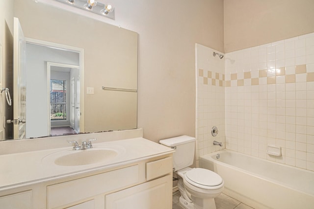 full bathroom featuring tile patterned flooring, tiled shower / bath, vanity, and toilet