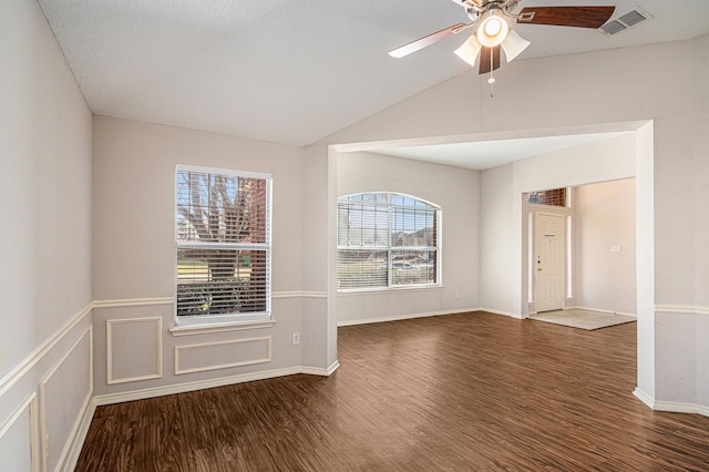 empty room with dark wood-type flooring, ceiling fan, and lofted ceiling