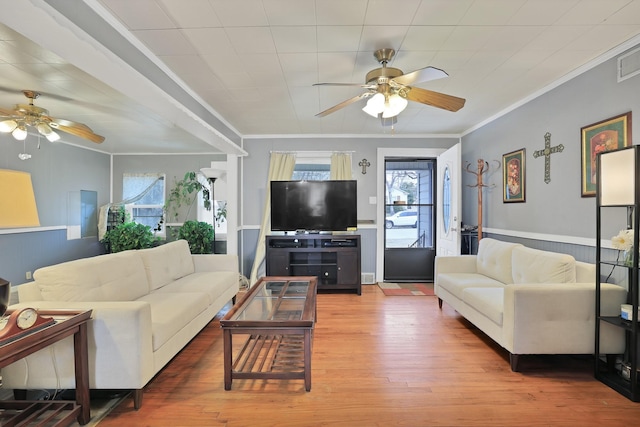 living room featuring ceiling fan, wood-type flooring, and crown molding