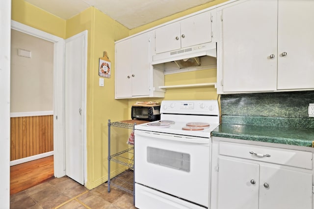 kitchen with light tile patterned flooring, white cabinetry, and electric range