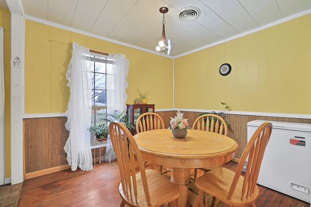 dining area featuring dark hardwood / wood-style floors and ornamental molding