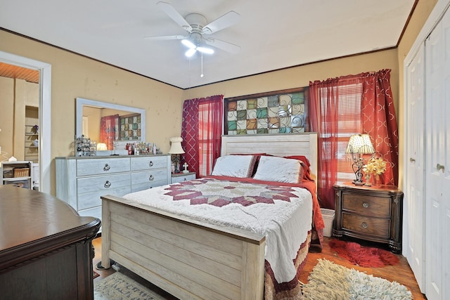 bedroom with ceiling fan, dark wood-type flooring, and a closet