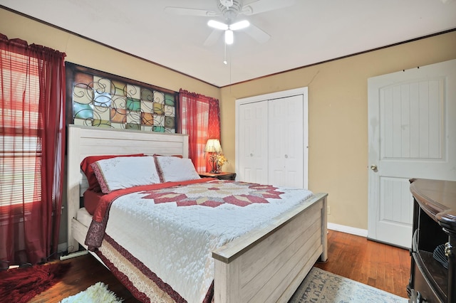 bedroom featuring ceiling fan, a closet, dark hardwood / wood-style flooring, and multiple windows