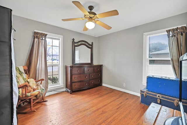 sitting room featuring light wood-type flooring, ceiling fan, and a healthy amount of sunlight