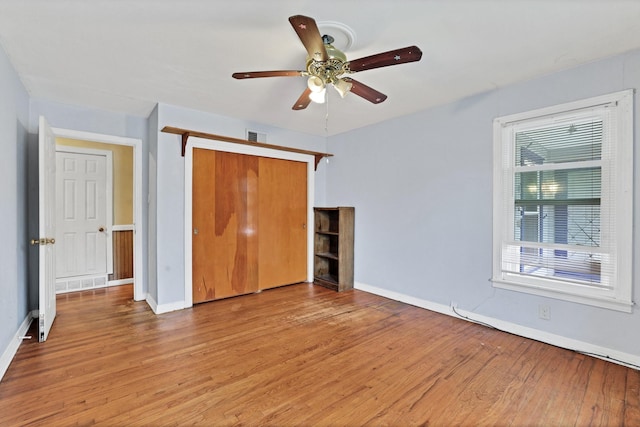 unfurnished bedroom featuring ceiling fan, a closet, and light wood-type flooring