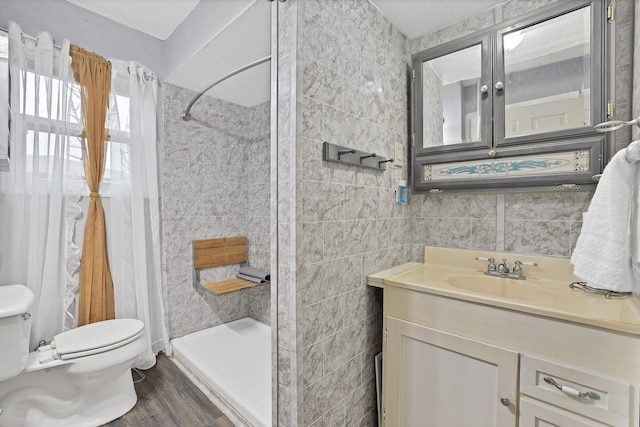 bathroom featuring toilet, hardwood / wood-style flooring, tile walls, a shower with curtain, and vanity