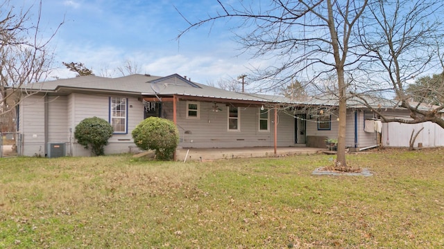 rear view of property featuring a patio, a lawn, and central AC