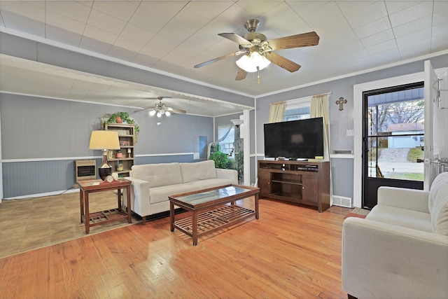 living room featuring light hardwood / wood-style floors, ornamental molding, and ceiling fan