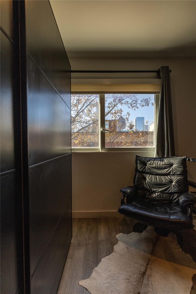 living area with a healthy amount of sunlight and dark hardwood / wood-style flooring