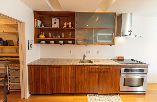 kitchen with exhaust hood, black electric stovetop, oven, sink, and light wood-type flooring