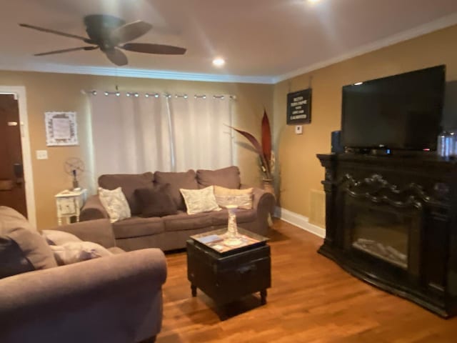 living room featuring ceiling fan, hardwood / wood-style floors, and ornamental molding