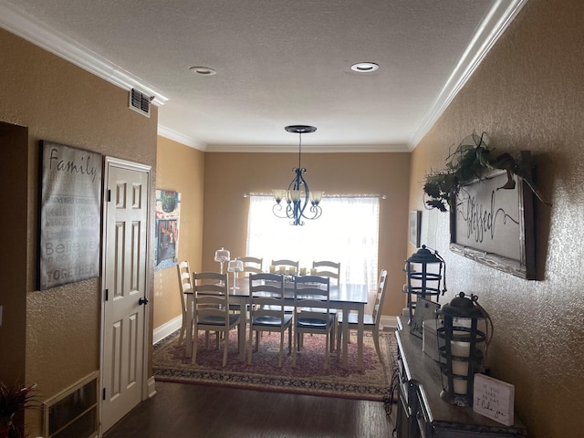 dining room featuring dark wood-type flooring, crown molding, and an inviting chandelier