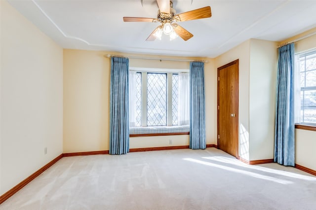 carpeted spare room with ceiling fan