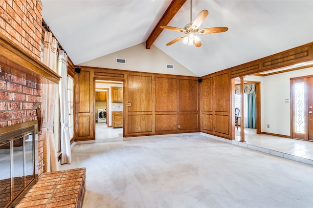 unfurnished living room with a fireplace, light carpet, beamed ceiling, and washer / clothes dryer